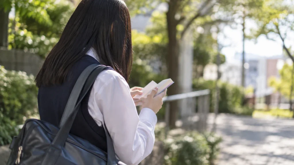通学中に単語帳を開く中学生