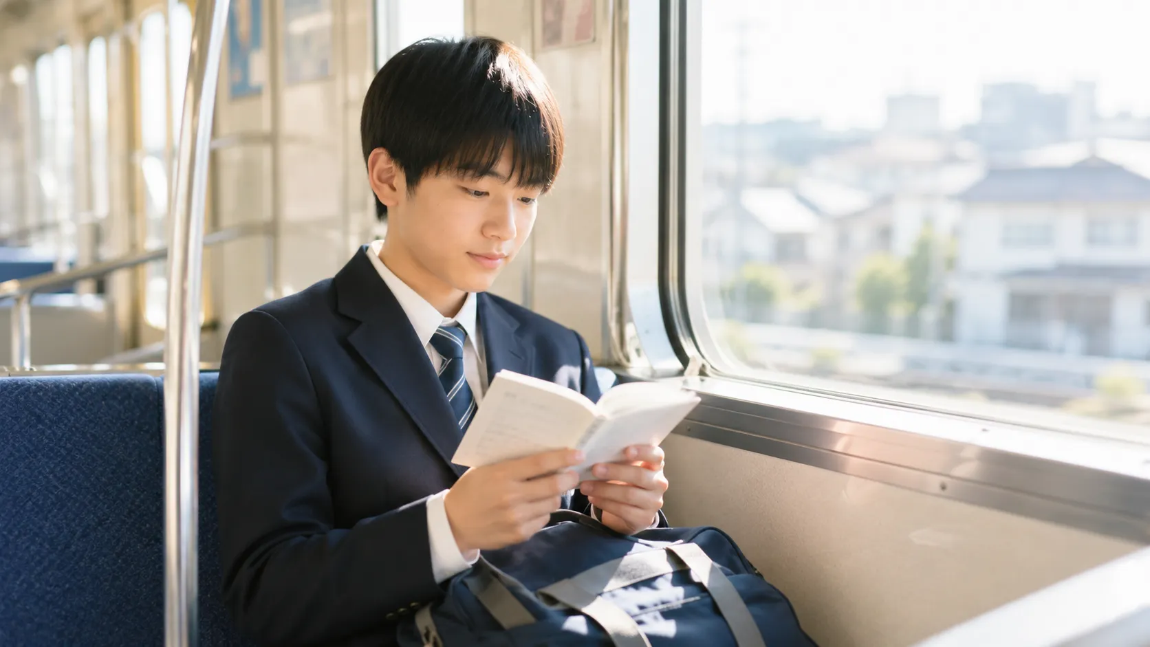 通学電車の中で単語帳を見ている中学生の様子